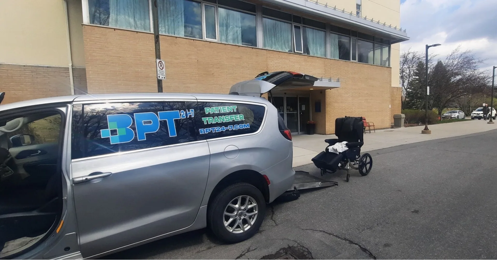 BRODA reclining wheelchair being loaded through the rear ramp of a BPT24-7 patient transfer van in Ottawa